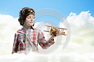 Boy in helmet pilot playing with a toy airplane