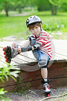 The boy in the helmet put on roller skates
