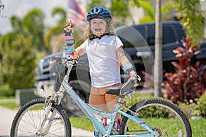 Boy in a helmet riding bike. Little cute adorable caucasian boy in safety helmet riding bike in city park. Child first