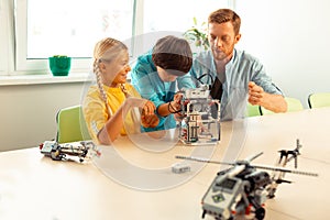 Boy helping his classmate building her robot.