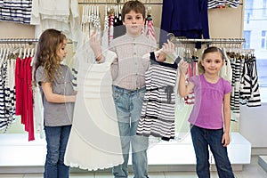 The boy helps cute girls to choose dress in shop