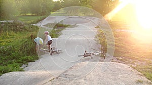 The boy helps the fallen cyclist to get off the track during the competitions