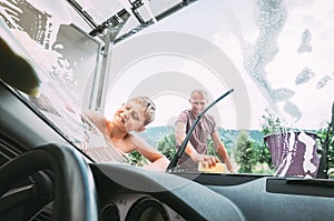 Boy helps his father with car washing photo