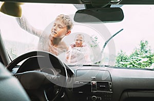 Boy helps his father to wash a car