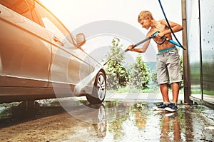 Boy helps to wash a car