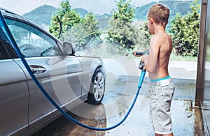 Boy helps to wash a car