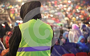 Boy with high visibility jacket and many people at stadium befor