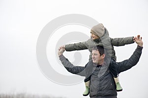 A boy and his dad are playing outside.