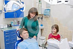 A boy with his family at the dentistÃ¢â¬â¢s in the clinic photo