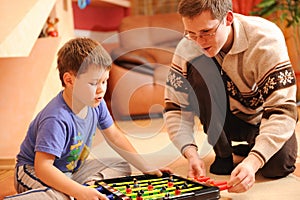 Boy and his father playing board soccer game at home