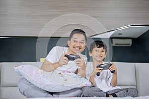 Boy and his father playing video game in bedroom