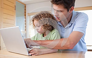 Boy and his father using a laptop