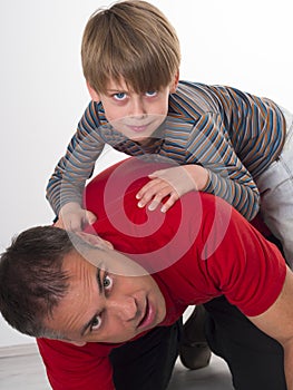 A boy on his fathers back, parenting can be diffic