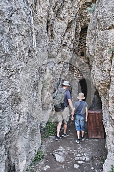 A boy and his grandfather walking into in a through grotto located in the rock photo