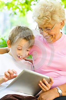 Boy with his grandmother using tablet