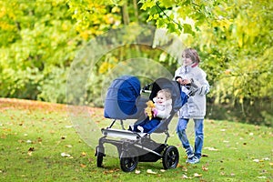 Boy with his little siblings in double hogger stroller