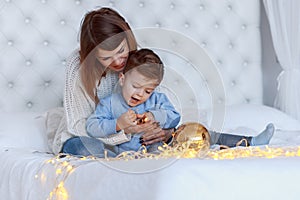 A boy with his mom in front of the christmas tree. happiness and big family concept