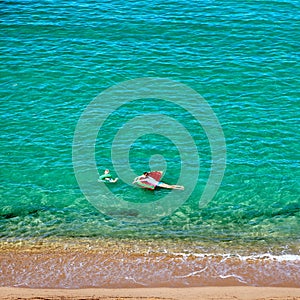 Boy and his mother on beach with inflatable float