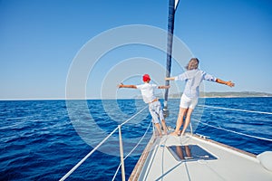 Boy with his mother on board of sailing yacht on summer cruise.