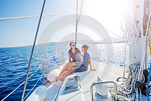 Boy with his mother on board of sailing yacht on summer cruise.