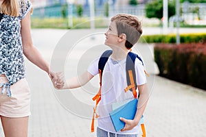 Boy with his mother at road to school.