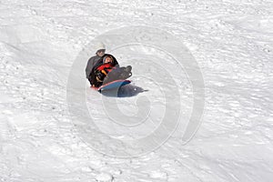 Boy and his mother sledding photo