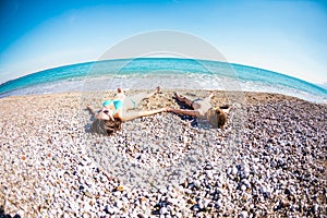 The boy with his mother sunbathe on the beach