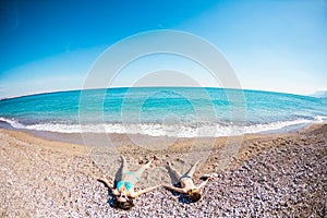 The boy with his mother sunbathe on the beach