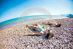 The boy with his mother sunbathe on the beach