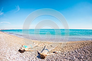 The boy with his mother sunbathe on the beach