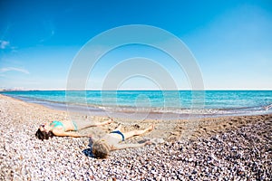 The boy with his mother sunbathe on the beach