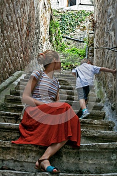 A boy and his mother are walking in the old town.