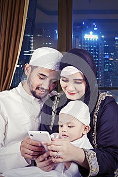 Boy and his parents using a mobile phone