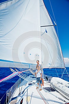 Boy with his sister on board of sailing yacht on summer cruise.