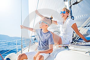 Boy with his sister on board of sailing yacht on summer cruise.