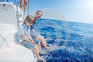 Boy with his sister on board of sailing yacht on summer cruise. Travel adventure, yachting with child on family vacation