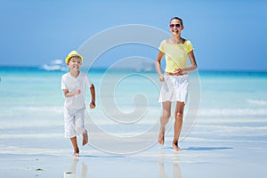 Boy with his sister having fun on tropical ocean beach. Kid during family sea vacation.