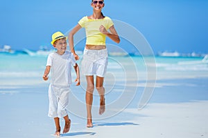 Boy with his sister having fun on tropical ocean beach. Kid during family sea vacation.