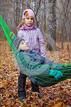 A boy with his sister relaxing in a hammock