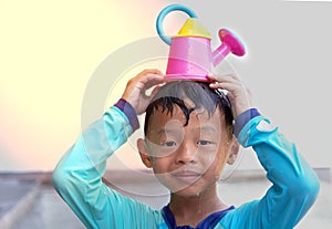 Boy hold water pouring on head with smile face in summer water play vacation holiday concept photo