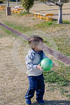 Boy Holding Ball in Playground