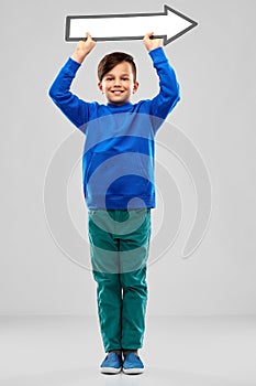 Boy holding big white rightwards thick arrow