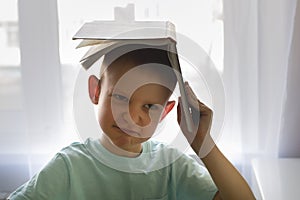 Boy holding a book over your head, do not want to read