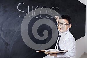 Boy holding book and write Success word