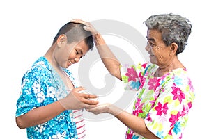 Boy holding bowl of water and flower pour down to old hands woman on white background