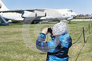 Boy holding camera and taking photos of old decommisioned planes