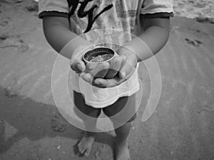 A boy holding a compass showing the direction point to north.