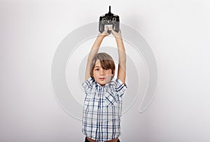 Boy holding the drone remote control above his head proudly