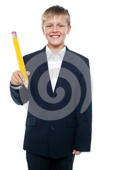 Boy holding giant sized yellow pencil