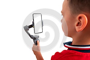 Boy holding gimbal with smart phone in vertical position. Isoalted background and display for mockup photo